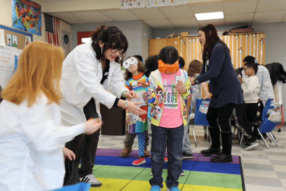 Mount Holyoke students guide first graders through goggle activity in Brain Basics workshop.