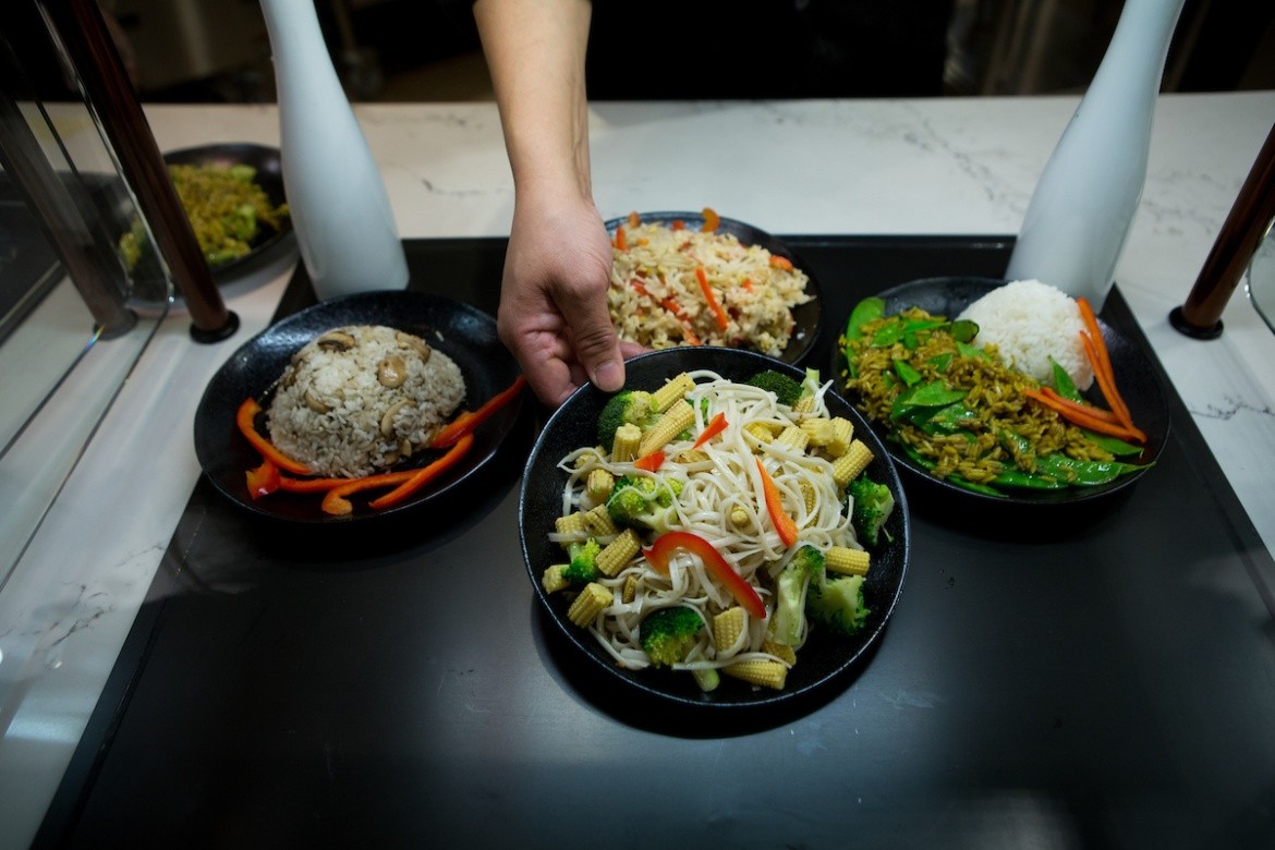 Four bowls of food from the dining hall, includes rice and vegetables.