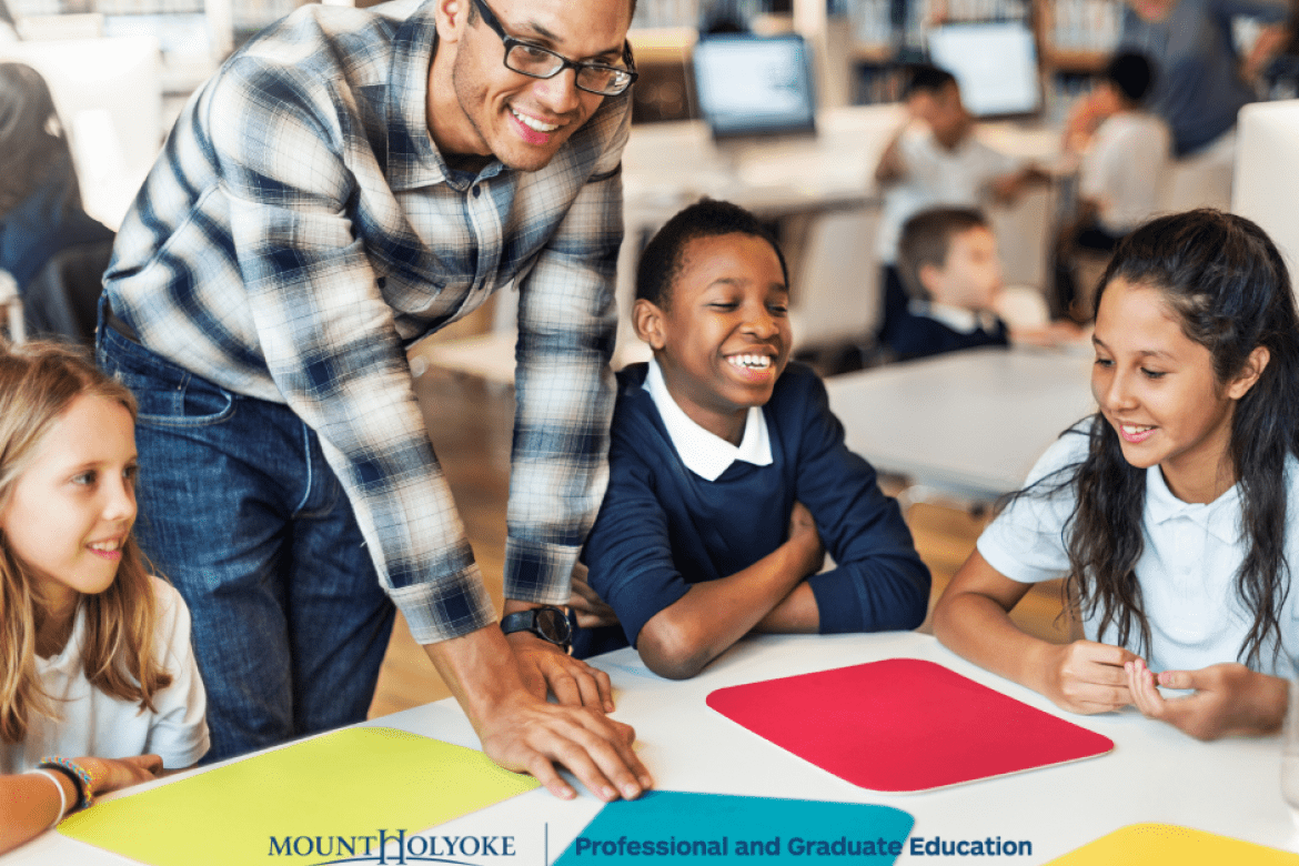 Students in a circle looking at colored pieces of paper.