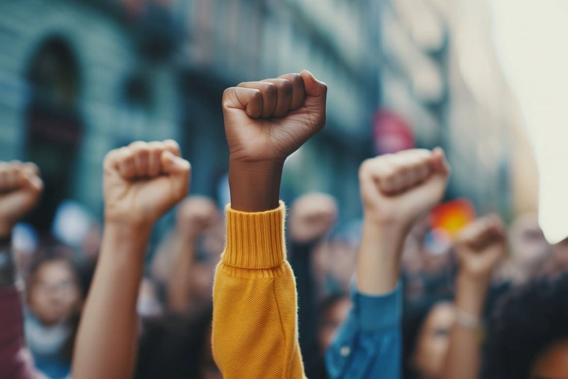 Fisted hands are raised in the air.