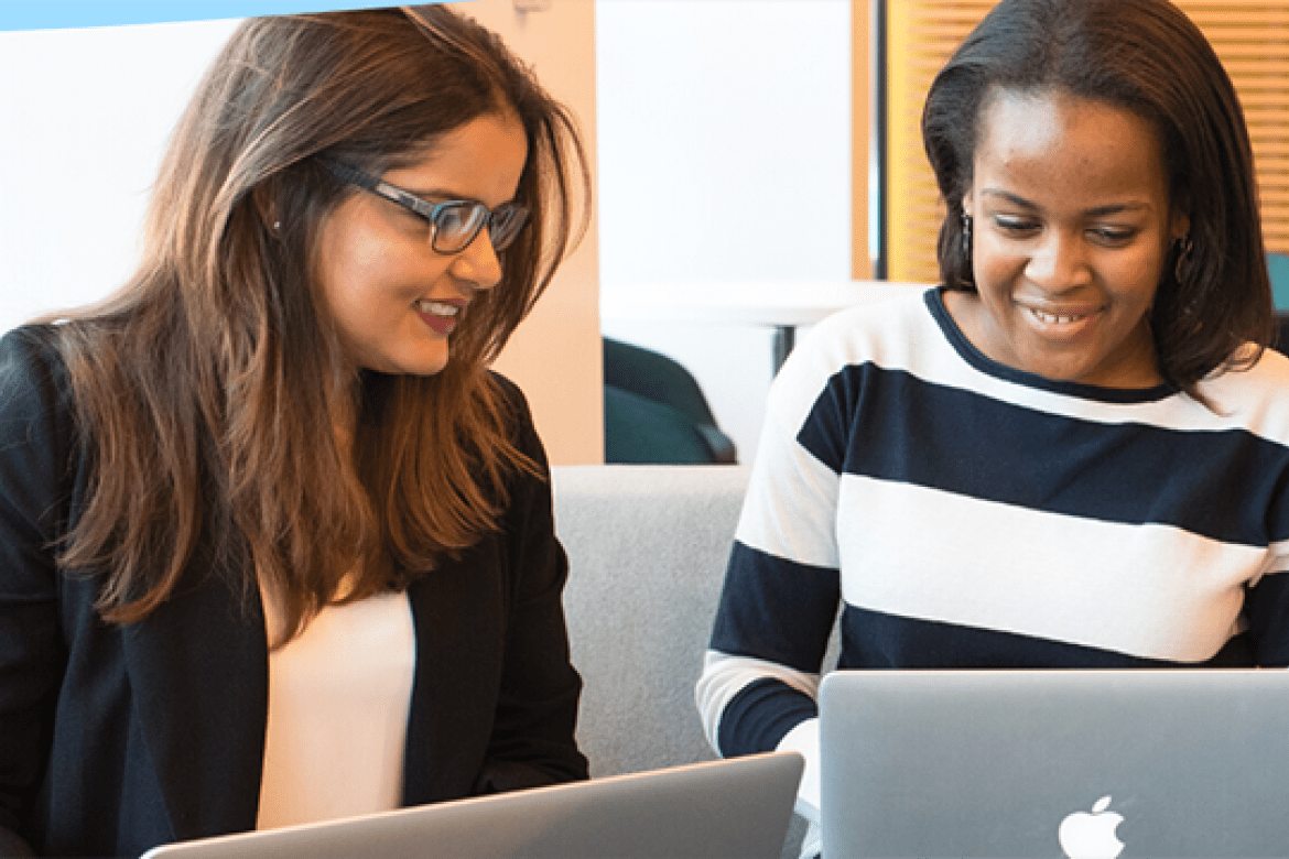 Master's students working together at their laptops