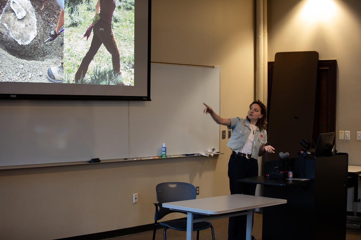 A student presents in front of a screen.