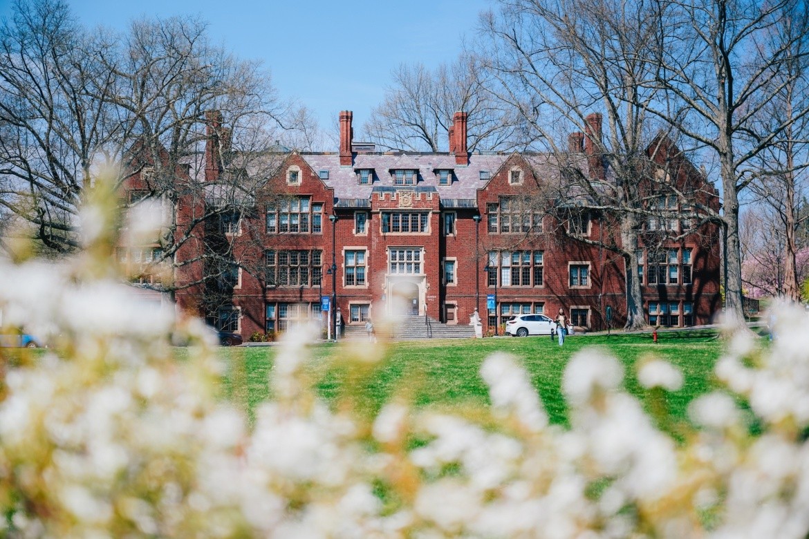 Skinner Hall on Mount Holyoke Campus, with blooms and greenery in the foreground.