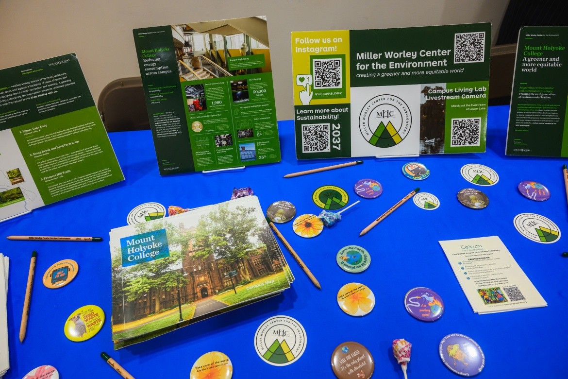 A table for the Summit on Feminist Leadership in Climate Justice with information, pins, pens, and other swag.