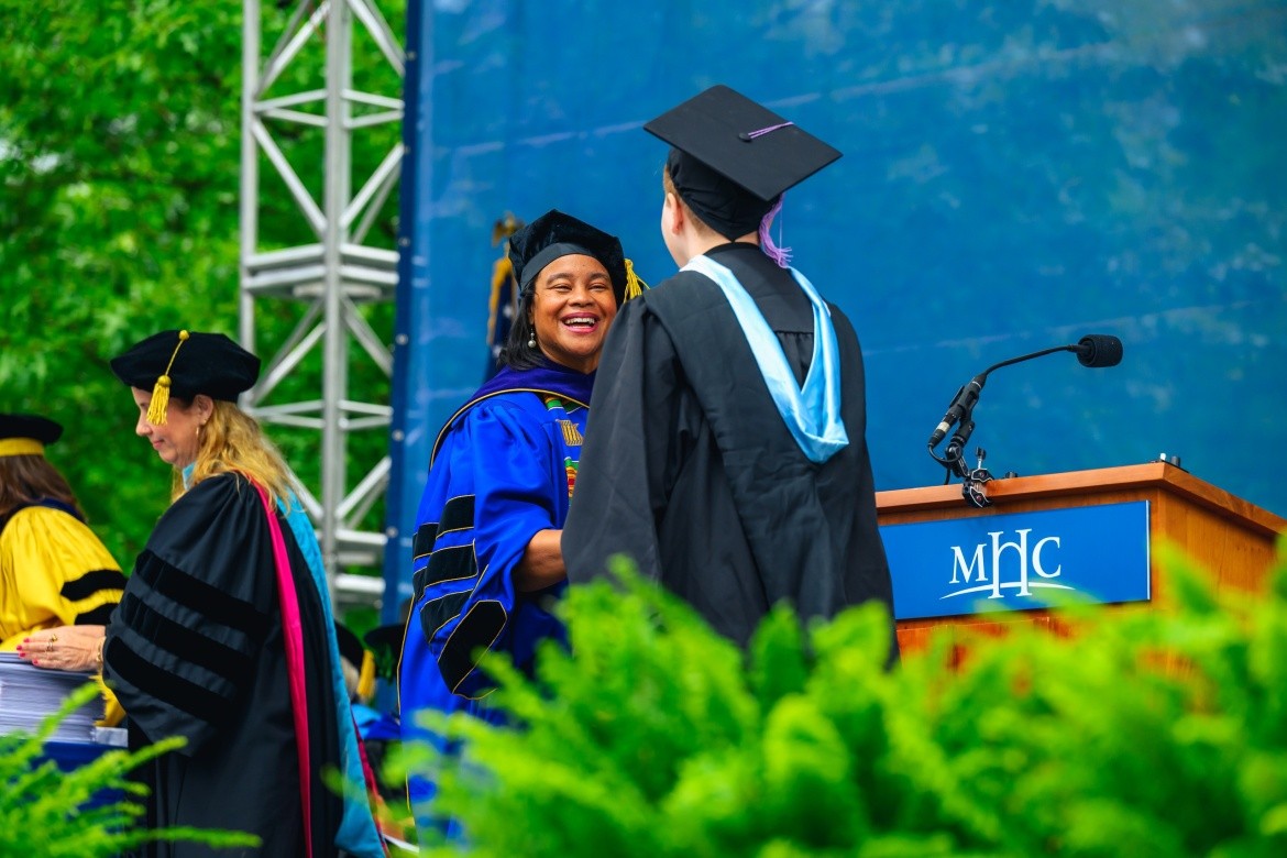 President Holley shakes hand of new graduate, Commencement 2025.
