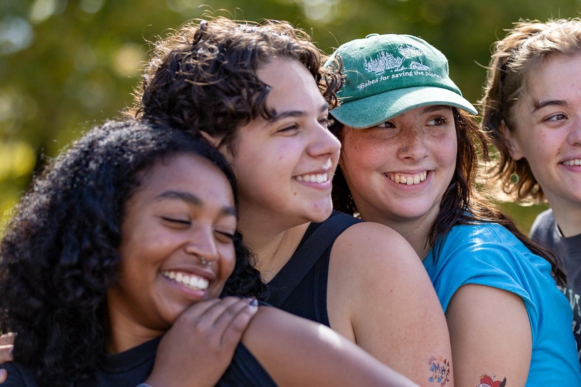 Four friends - Mount Holyoke students - pose for a photo at the top of Mt. Holyoke on Mountain Day, 2025. Photo by Max Wilhelm.