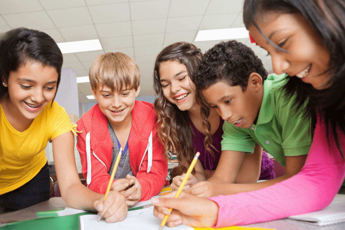 Mount Holyoke Professional and Graduate Education - students in a group smiling and writing on paper