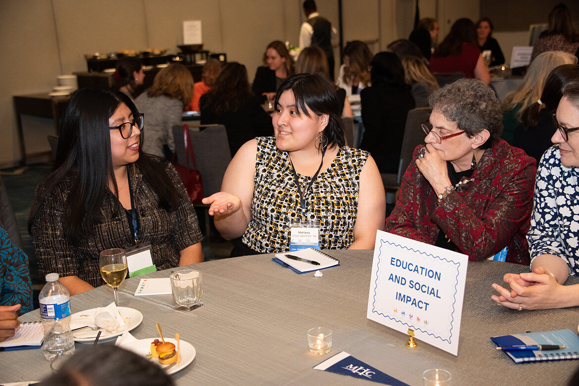 Mount Holyoke College alums and students at the Education and Social Impact table at the alum networking reception.