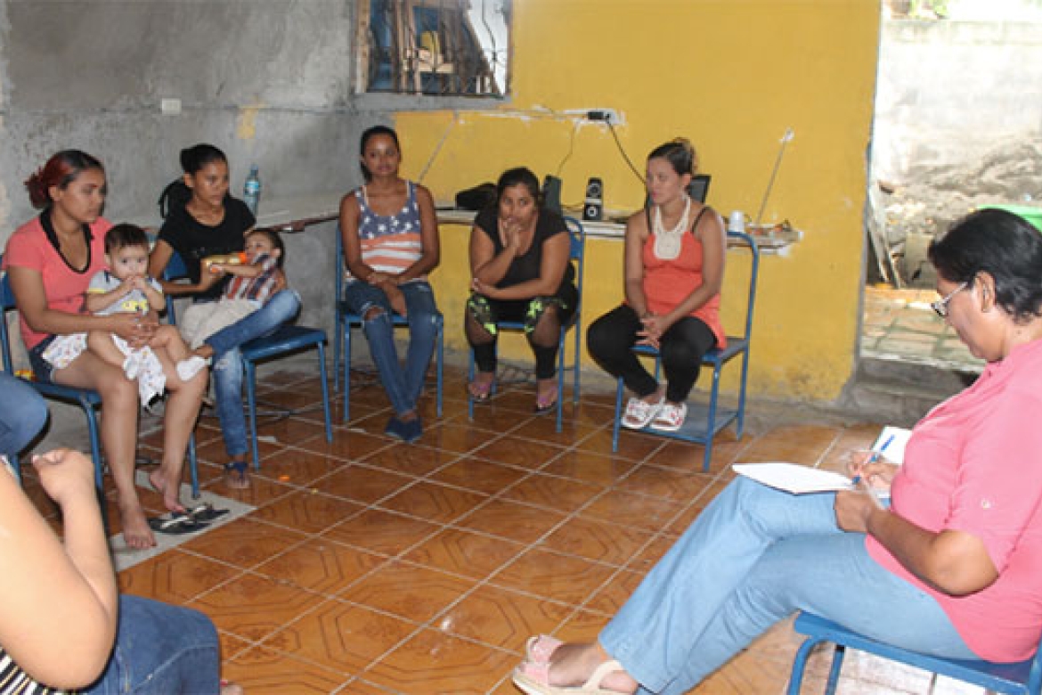 A group of you mothers gather inside the community center to work with a psychologist.