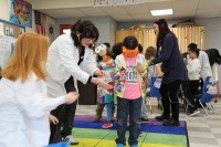 Mount Holyoke students guide first graders through goggle activity in Brain Basics workshop.
