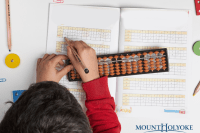 Student doing math with a bead board.