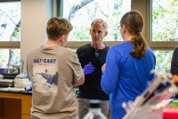 Craig Woodard in the Eukaryotic Molecular Genetics Lab with two students. Photo by Max Wilhelm.