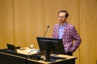 Adam Hilton presenting at “What to Expect in the 2024 US Elections,” held in October 2024.