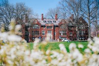 Skinner Hall on Mount Holyoke Campus, with blooms and greenery in the foreground.