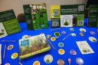 A table for the Summit on Feminist Leadership in Climate Justice with information, pins, pens, and other swag.