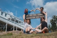 Students making a heart shape with their arms around the Mt. Holyoke state park sign. Mountain Day 2024. Photo by Max Wilhelm.
