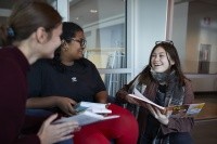 Students sat together, smiling, holding books.