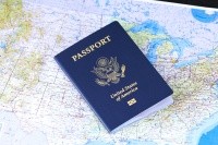 A blue American passport lies atop a map of the world.