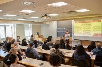 A student presenting in front of a lecture hall during Senior Symposium