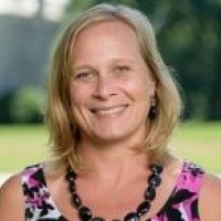 Amanda Mayfield, a woman with short blond hair wearing a black necklace and a pink and black top.