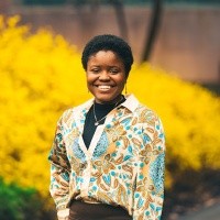 Oluwafadeyemi Testimony Akinkuolie-Ibidapo ’27 in front of yellow flowers. Photo by Max Wilhelm, 2025.