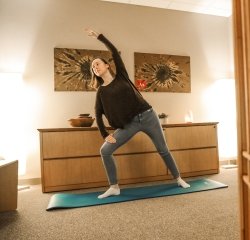 student-stretching-yoga-mat.jpg A student stretching on a yoga mat