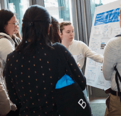 A student from the Berry lab explaning a poster presentation on their research to other students