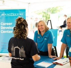 Staff from the Career Development Center talk with a student at an information table
