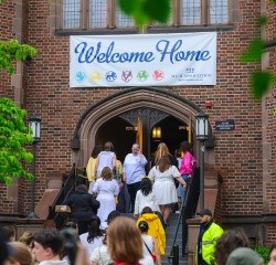Reunion II parade participants enter into Mary Woolley with a Welcome Home sign overhanging the arched door