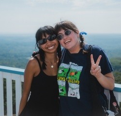 Two students at the summit house looking at the camera smiling during Mountain Day 2024. Photo by Max Wilhelm.
