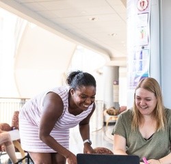 Two Professional and Graduate students working together with a computer.