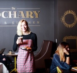 A student carrying food to a table in the Cochary Pub