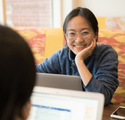 A student sits attentively listening to another student