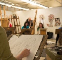 A group of students drawing still life in an art studio
