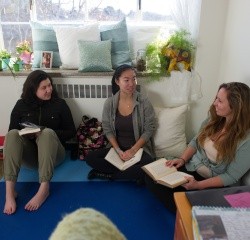 Three students sitting on the floor having a conversation