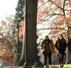 A group of three students walking on the Mount Holyoke campus in the fall