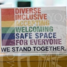 Sign on door that reads "Diverse, Inclusive, Accepting, Welcoming, Safe Space for Everyone, we stand together".