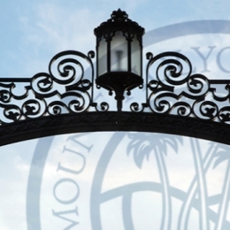 A lantern and metal scrollwork arch, the gates of MHC.