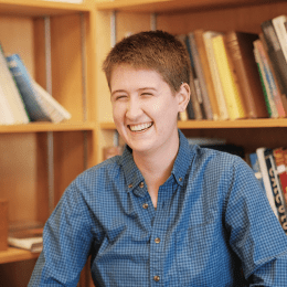 Piper LaPointe ’23 sitting in front of a bookcase full of books