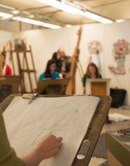 A group of students drawing still life in an art studio
