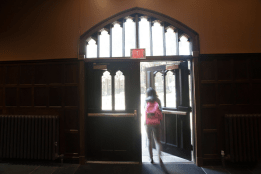A student opening a door to exit a bulding
