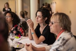 Professional and Graduate students listening attentively to a presentation