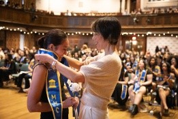 Faculty mentor puts stole on student in stoling ceremony, 2024.