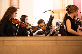 Student orchestra plays instruments.