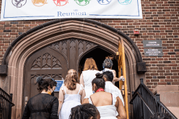 Alums walking up the steps to go into Chapin Auditorium, underneath the Welcome Home banner