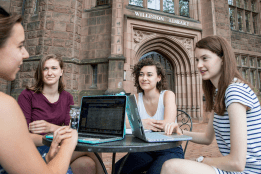 Computer science students sitting together at a table outside the library