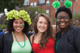 A group of three students displaying their class colors before Convocation