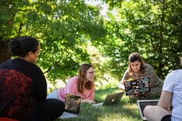 Professional and Graduate students outdoors in a discussion group.