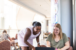 Two Professional and Graduate students working together with a computer.