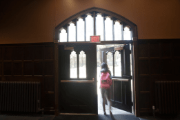 A student opening a door to exit a bulding
